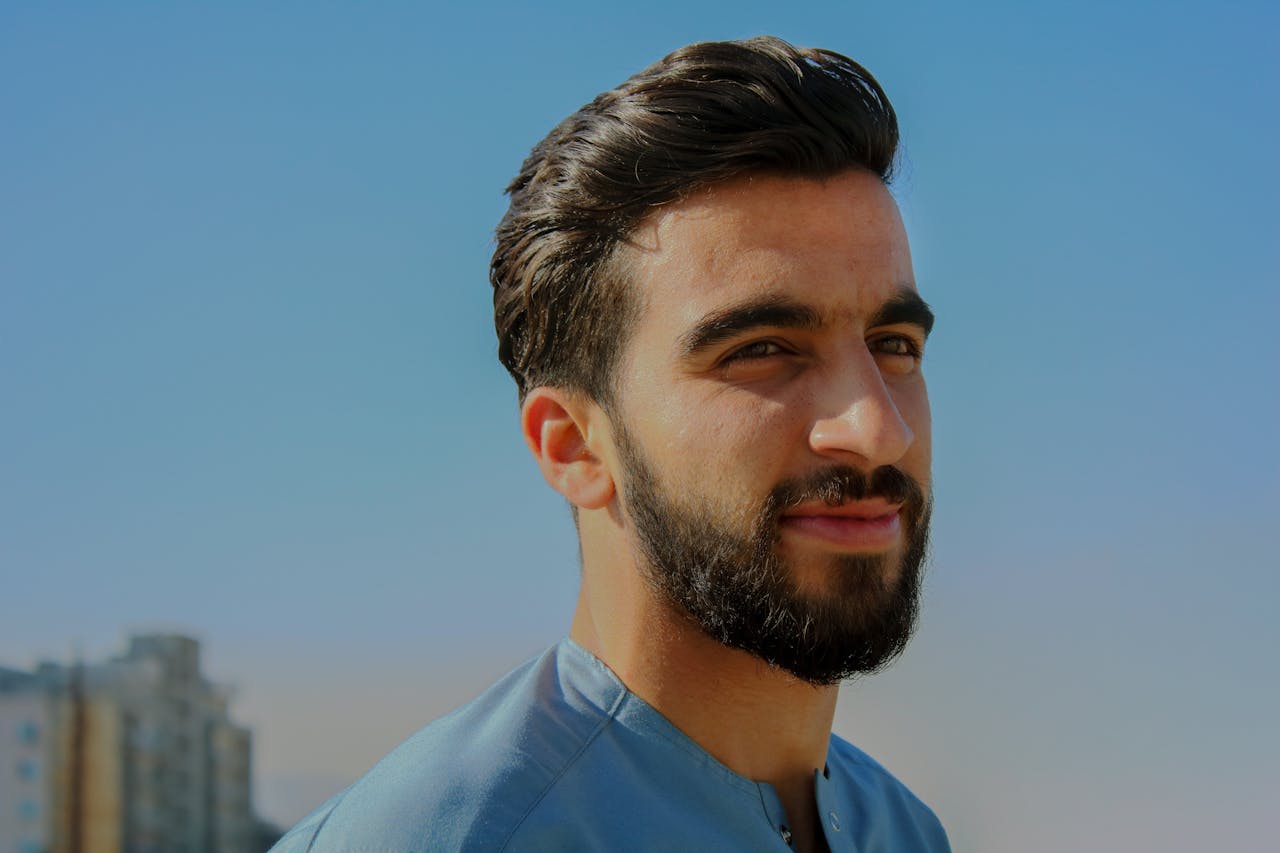 Man with shiny black hair wearing a blue tshirt