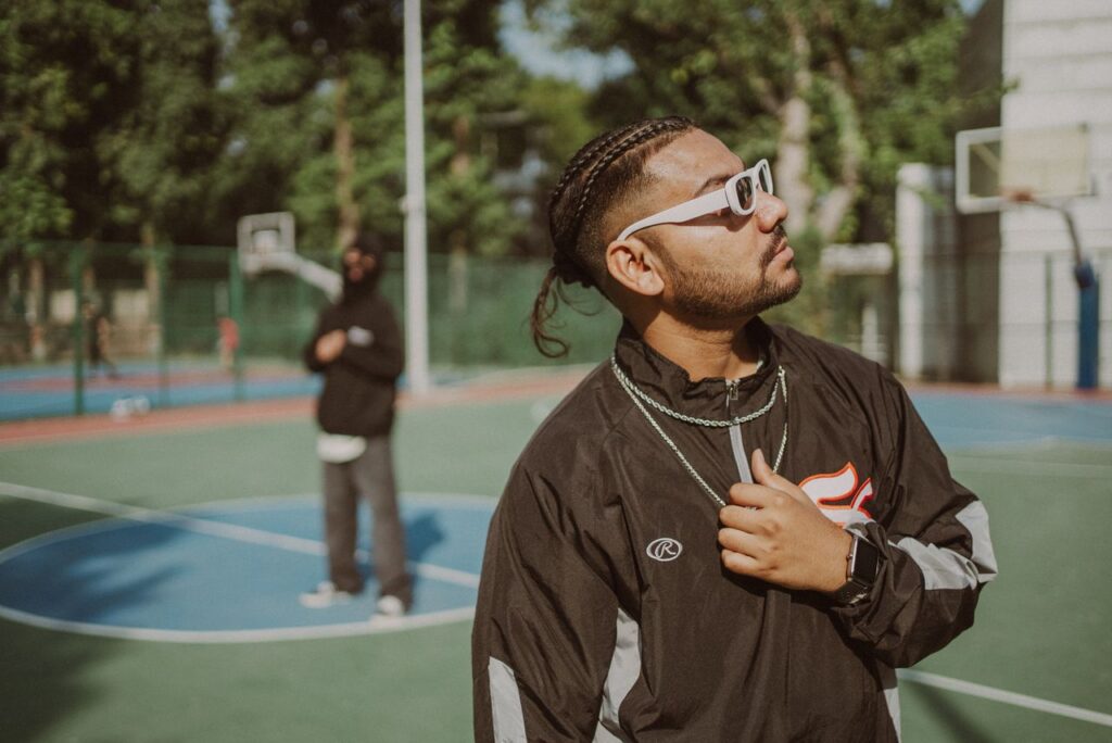 pexels-photo-20097558-20097558 Man in fashionable tracksuit and sunglasses at outdoor basketball court. Urban vibe.