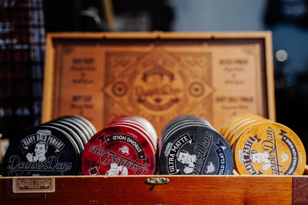 pexels-photo-5192478-5192478 Close-up of various vintage-style hair products in a wooden box with decorative design.