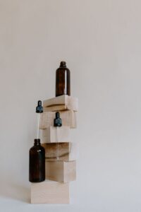 Brown glass essential oil bottles arranged on wooden blocks in a minimalist style.