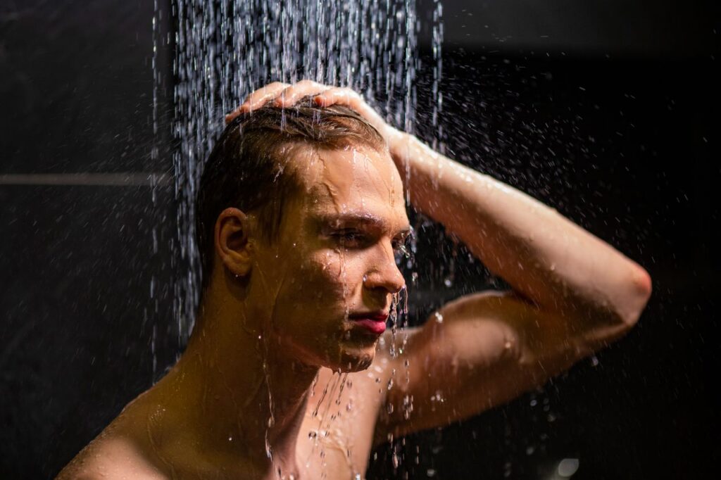 pexels-photo-7365400-7365400 Portrait of a handsome man under a shower, highlighting water droplets and a pensive expression.
