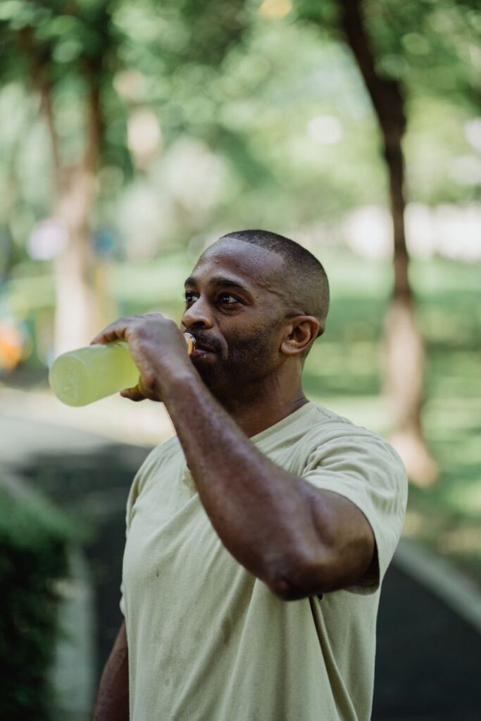 pexels-photo-4803670-4803670 Adult man in park drinking energy drink post-workout, capturing a refreshing moment.