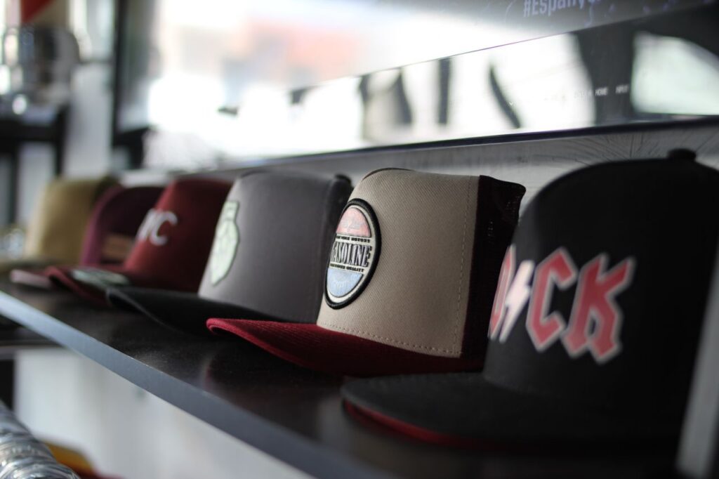 pexels-photo-31162881-31162881 Collection of trendy baseball caps arranged on a store shelf, showcasing different designs.